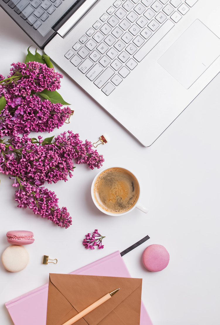 Modern feminine workplace with coffee and flowers